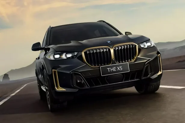 Juodas BMW X5 automobilis važiuoja keliu saulėlydžio fone.